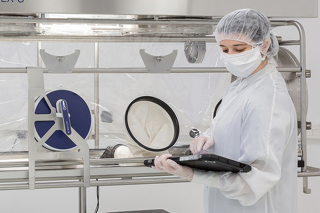 An operator using a Glove Leak Tester to test the isolator glove and sleeve integrity An operator using a Glove Leak Tester to test the isolator glove and sleeve integrity